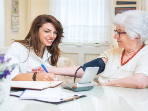 caregiver checking the blood pressure of senior woman