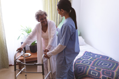 caregiver assiting senior woman to stand