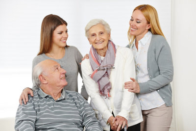 senior couple and their caregiver smiling